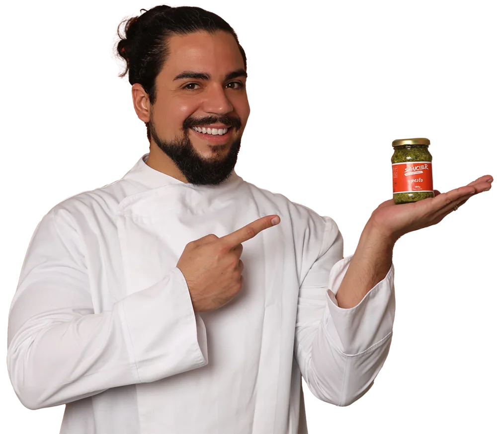 Chef Mauricio Lacerda apontando para um pote de pesto Saucier